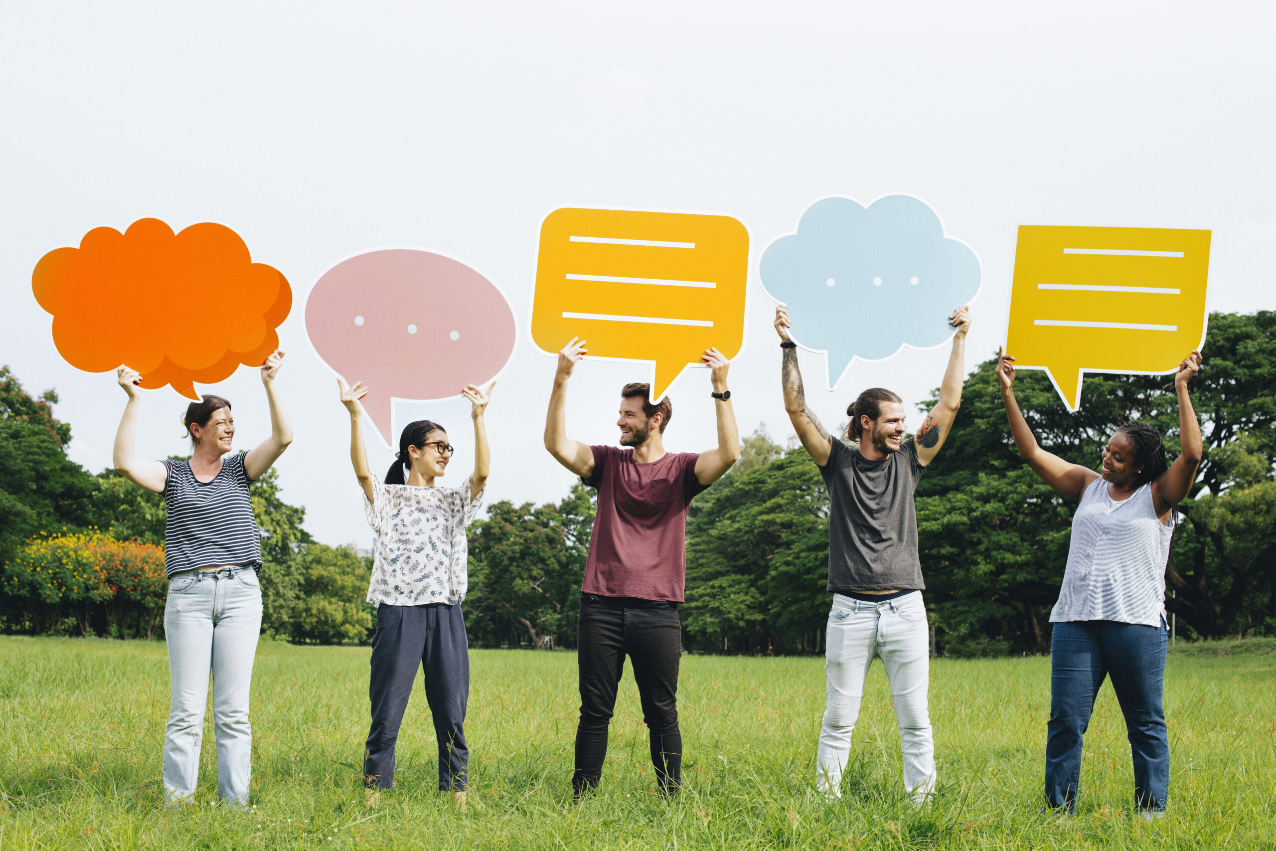 Happy diverse people holding colorful speech bubbles